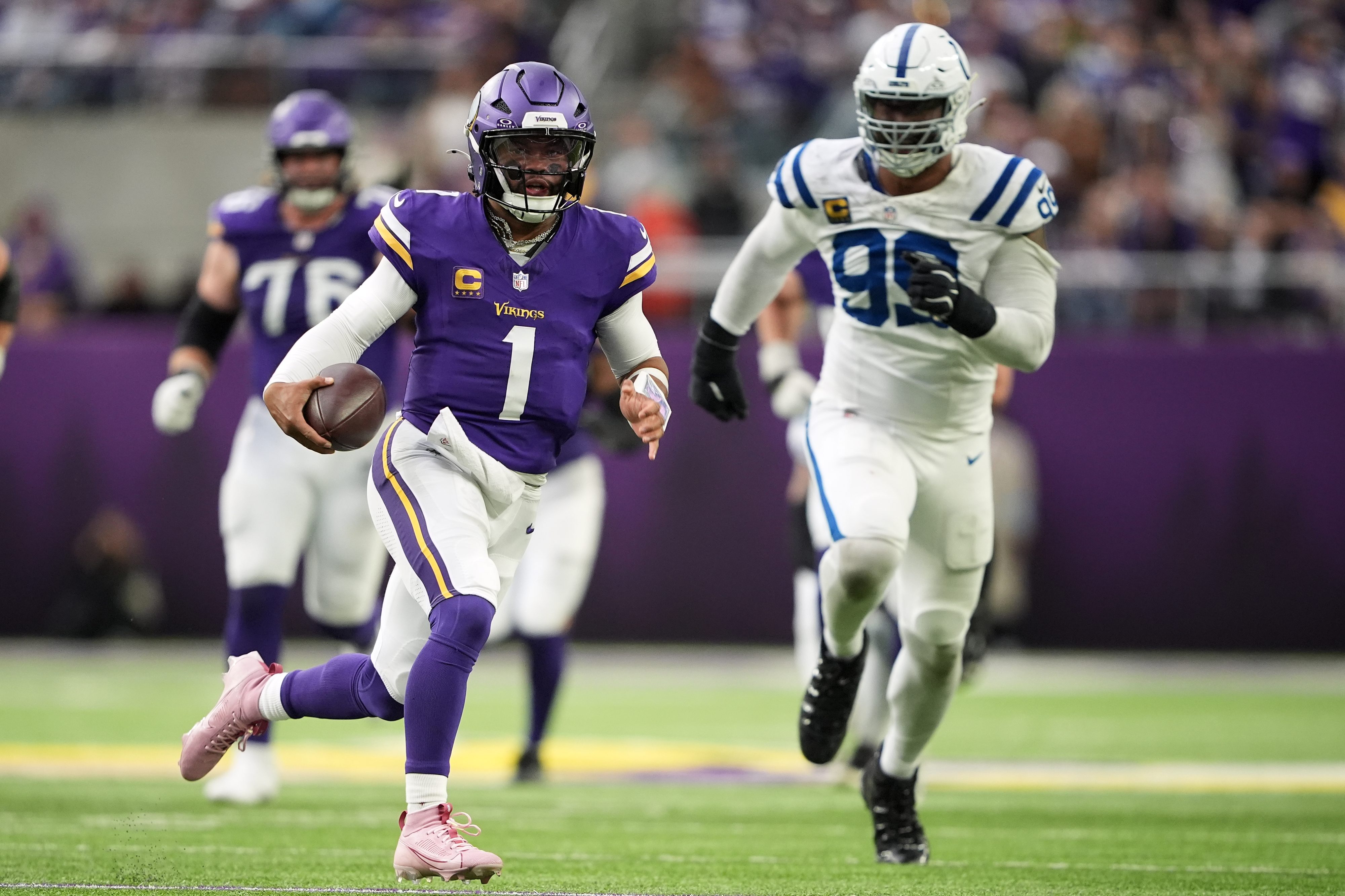 Kyler Murray scrambling with a football, defenders in pursuit